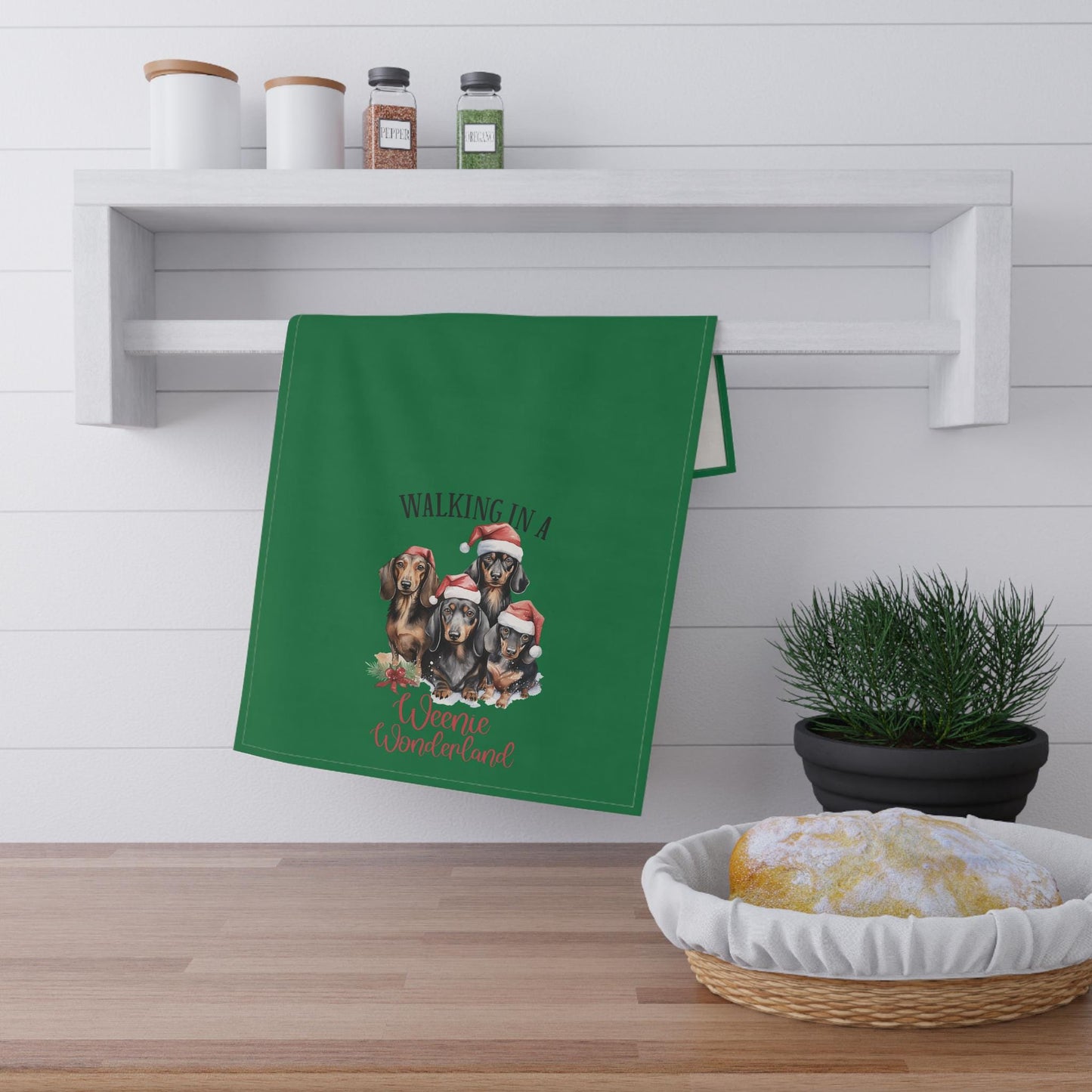 Green novelty tea towel with three Winnie dogs that says walking in no weenie Wonderland